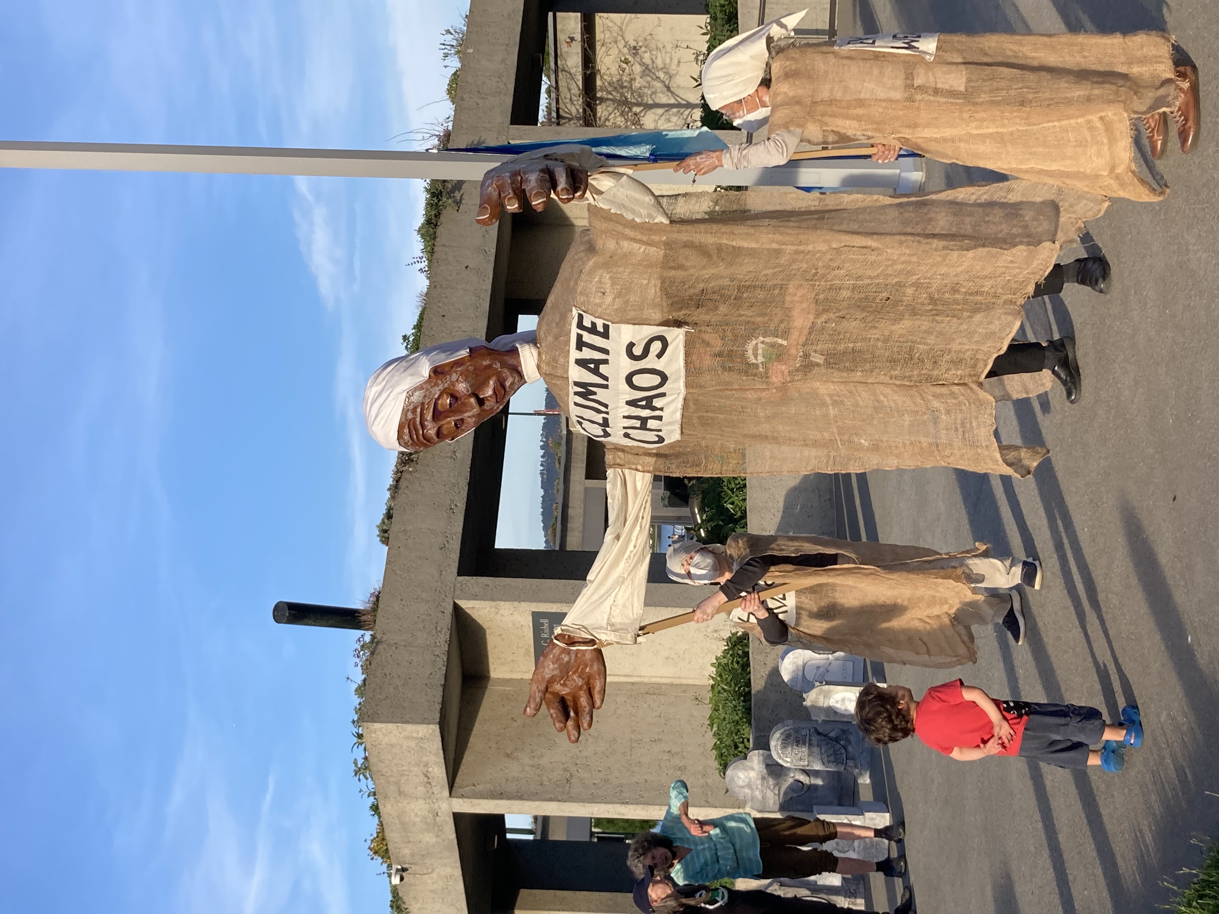 Large puppet dressed in burlap held by two Lamentors